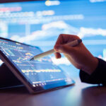 a person using a pen to point at a stock chart on a tablet