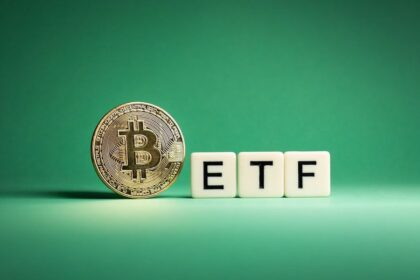 bitcoin coin beside letter blocks spelling etf on a green background