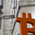 bitcoin logo in from of wall st sign