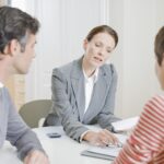 couple looking over documents with financial advisor mortgage lender