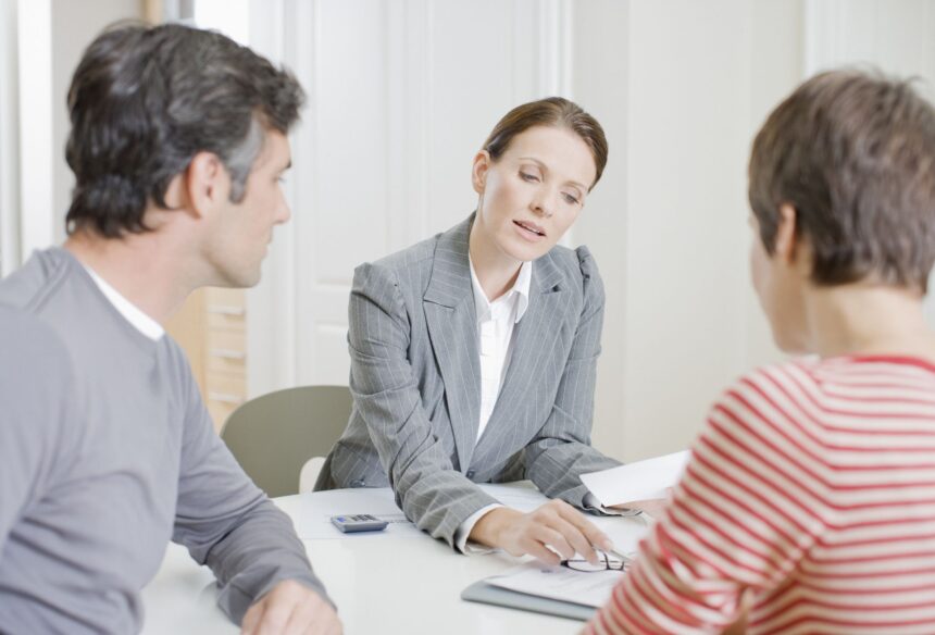 couple looking over documents with financial advisor mortgage lender