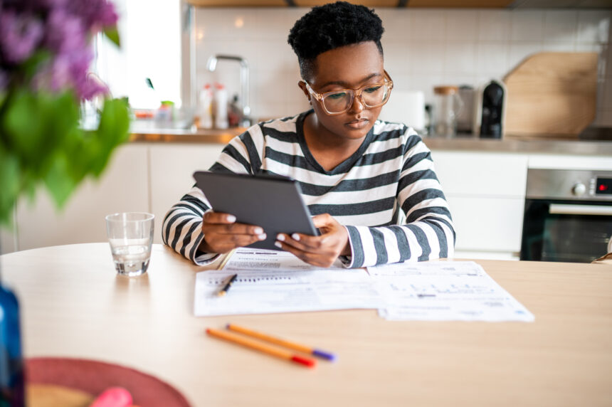investors considers papers on a table while holding a tablet