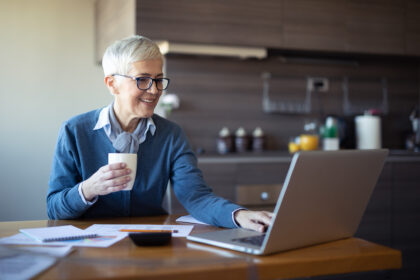 investors drinks and examines laptop