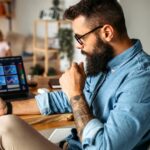 man examines cryptocurrency investments home laptop iStock 1347340865