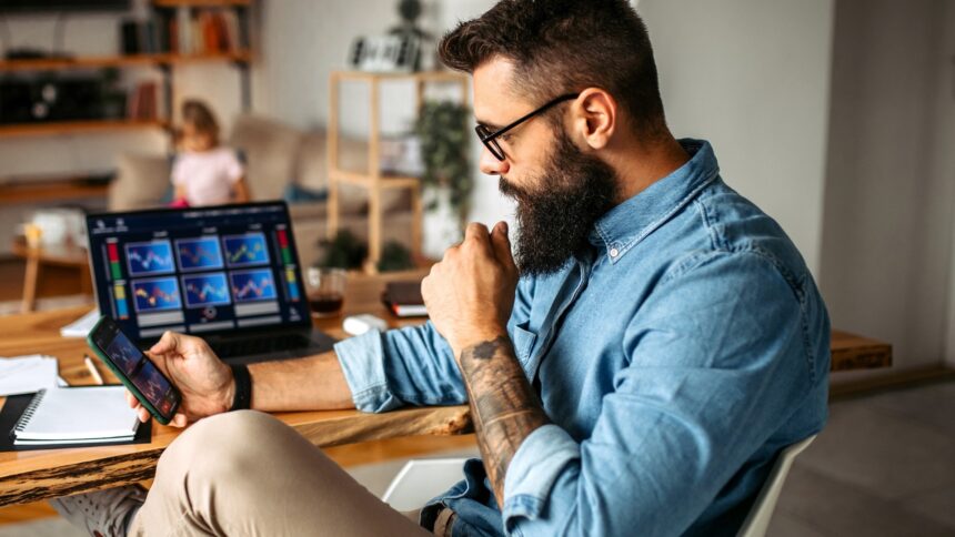 man examines cryptocurrency investments home laptop iStock 1347340865