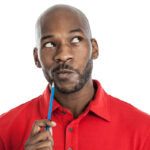 person holding pencil to chin while pondering thinking