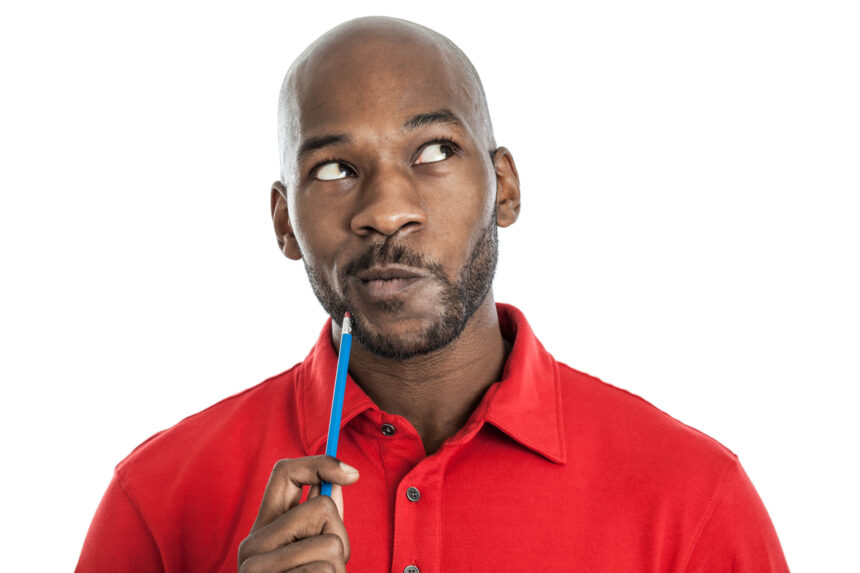 person holding pencil to chin while pondering thinking