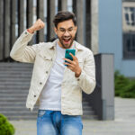 young smartphone user celebrating