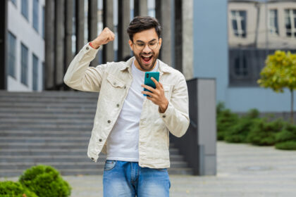 young smartphone user celebrating