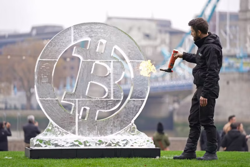 1236769545 ice sculptor csaba vass puts the finishing touches to a large bitcoin ice carving in fron