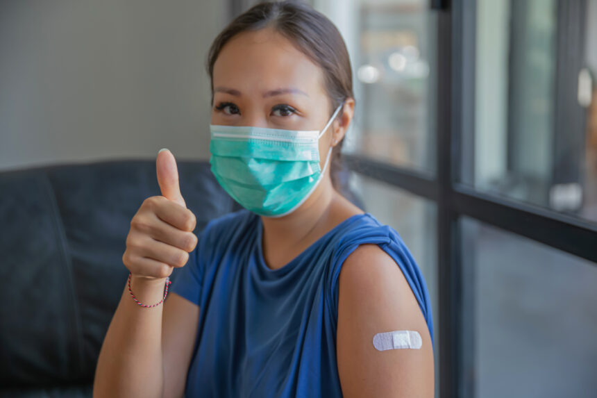 person giving the thumbs up after receiving a vaccination shot