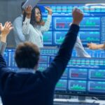 wall street traders looking at graphs and charts cheering because the stock market went up