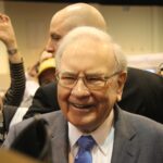 warren buffett smiling surrounded by cameras