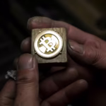 910099828 tokyo japan a worker polishes a brass bitcoin medal produced by sakamoto metal at a worksh