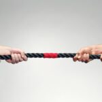 102416294 hands pulling on rope during game of tug of war