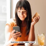 SOCIAL IMAGE PARTNER OFFER TERMS APPLY woman with credit card using smart phone in cafe Westend61 30